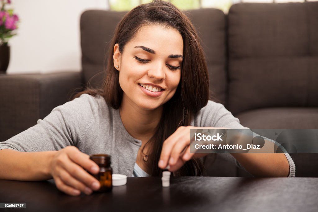 Playing around with some pills Cute girl sorting and playing with some of her vitamins at home and smiling 20-29 Years Stock Photo