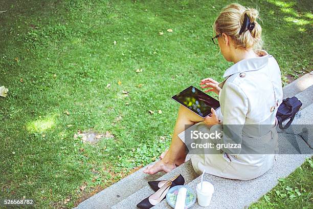 Young Businesswoman On A Lunch Break In Park Stock Photo - Download Image Now - Grass, One Woman Only, Reading