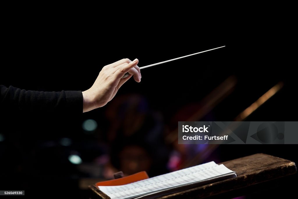 conductor's hand conductor's hand on a black background Musical Conductor Stock Photo