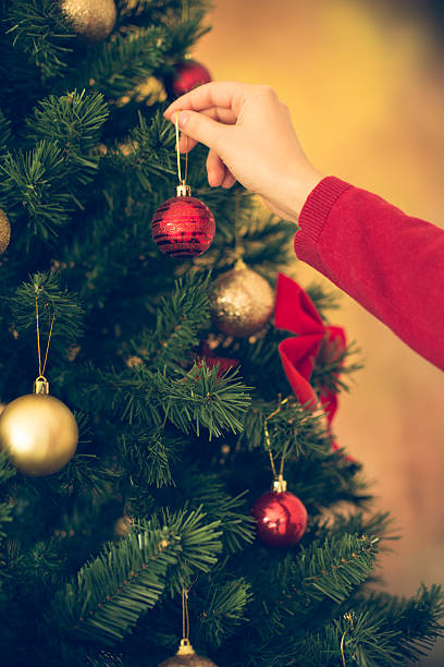 istock Woman hanging baubles on Christmas tree 526572503