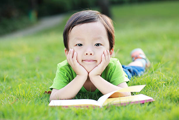 istock The children read a book on the grass 526594711