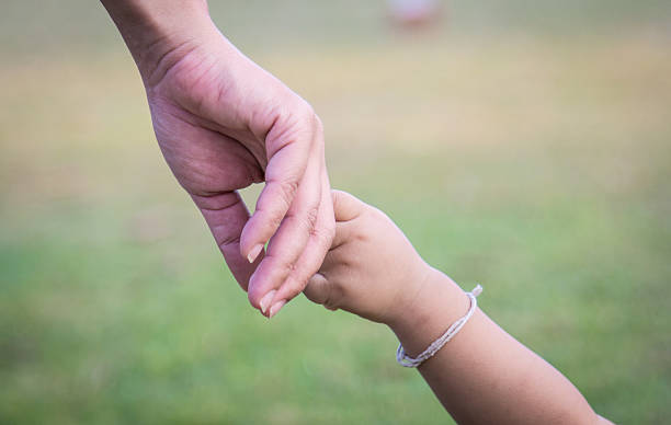 istock hands of mother and child 526596899