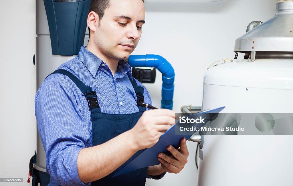 Plumber at work Technician servicing an hot-water heater Adult Stock Photo