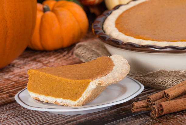 istock Slice of a pumpkin pie and pumpkins on the background 526597247