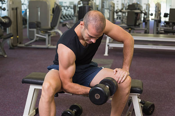 istock Young man exercising with dumbbell in gym 526597261
