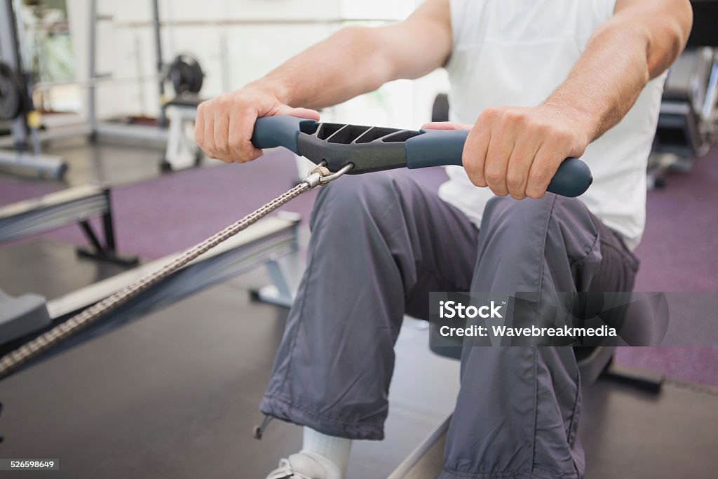 Fit man working out on rowing machine Fit man working out on rowing machine at the gym 40-44 Years Stock Photo