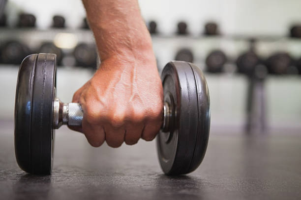 istock Fit man lifting heavy black dumbbell 526600101