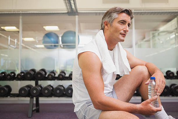 istock Fit man taking a break in the weights room 526600143