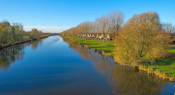 istock Trees along a canal under sunny sky in autumn 526601213
