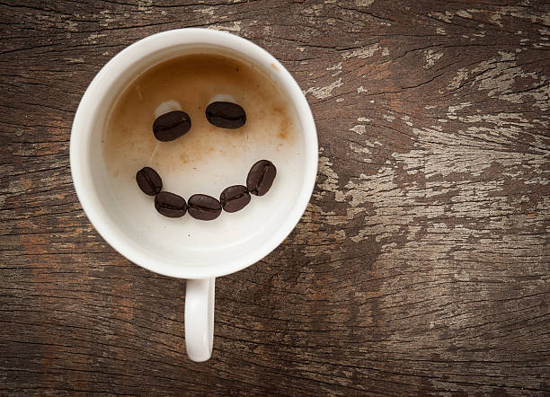 istock Empty cup of espresso coffee with smiling coffee beans 526637023