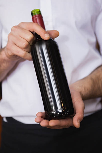 istock Handsome waiter holding a bottle of red wine 526638401