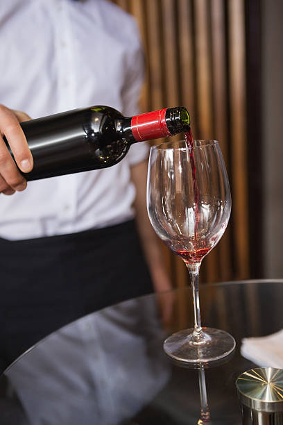 istock Waiter pouring a bottle of red wine 526638407