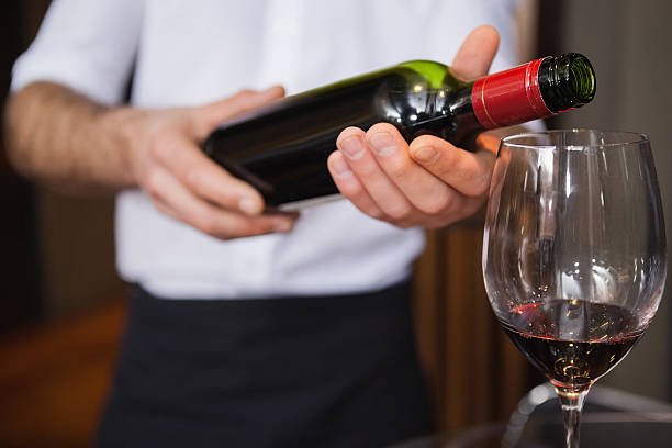 istock Waiter pouring a bottle of red wine 526638413