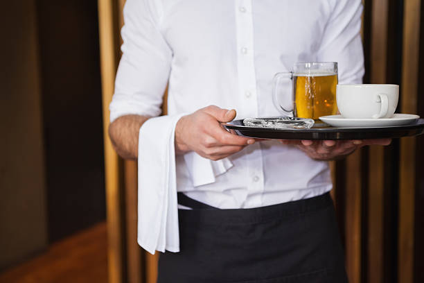 istock Waiter holding tray with coffee and beer 526638491