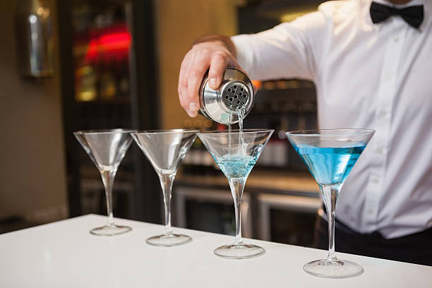 istock Bartender pouring blue alcohol into cocktail glass 526638769