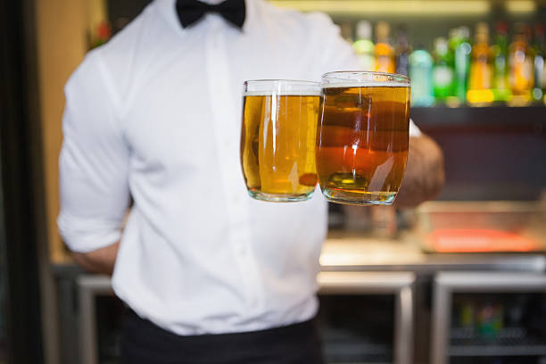 istock Bartender holding two glasses of beer 526638847