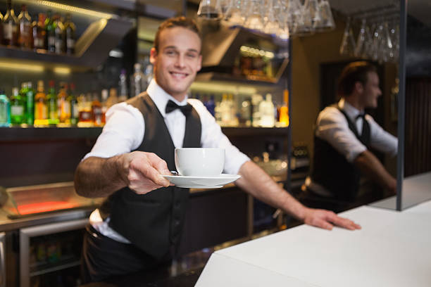 istock Smiling waiter offering cup of coffee smiling at camera 526638861