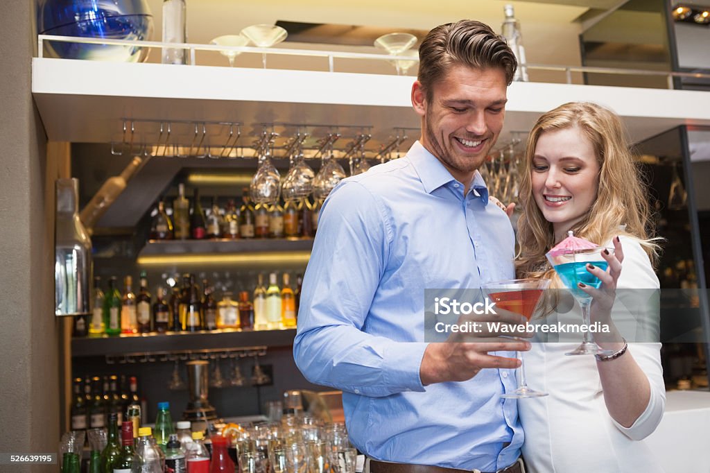 Cute couple standing and drinking cocktails Cute couple standing and drinking cocktails at the night club 20-24 Years Stock Photo