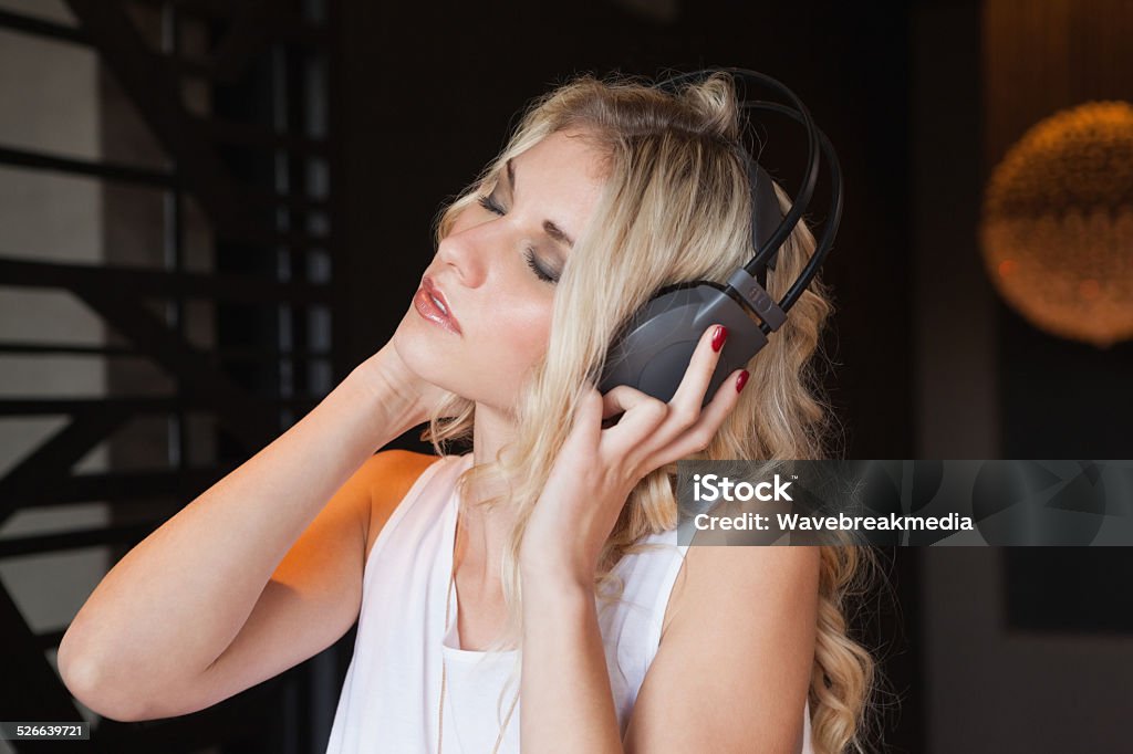 Pretty blonde listening to music with eyes closed Pretty blonde listening to music with eyes closed at the nightclub 18-19 Years Stock Photo