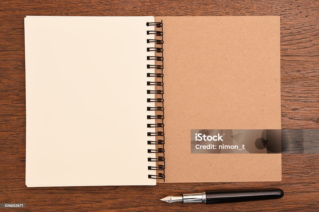 Open notebook and pen Open notebook and pen on wooden background. Blank Stock Photo