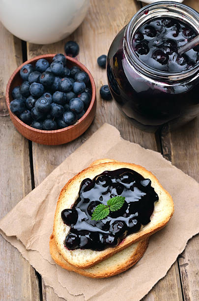 pain avec confiture de myrtille sur table en bois - gelatin dessert blueberry blue dessert photos et images de collection