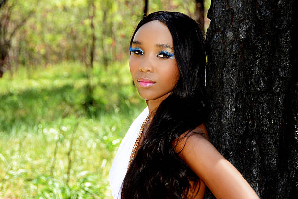 Young Beautiful African Woman Leaning Against a Tree in the African Bush
