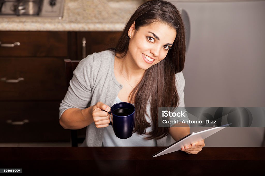 Having coffee for breakfast Top view of a beautiful young Hispanic woman having a cup of coffee for breakfast and using a tablet computer 20-29 Years Stock Photo