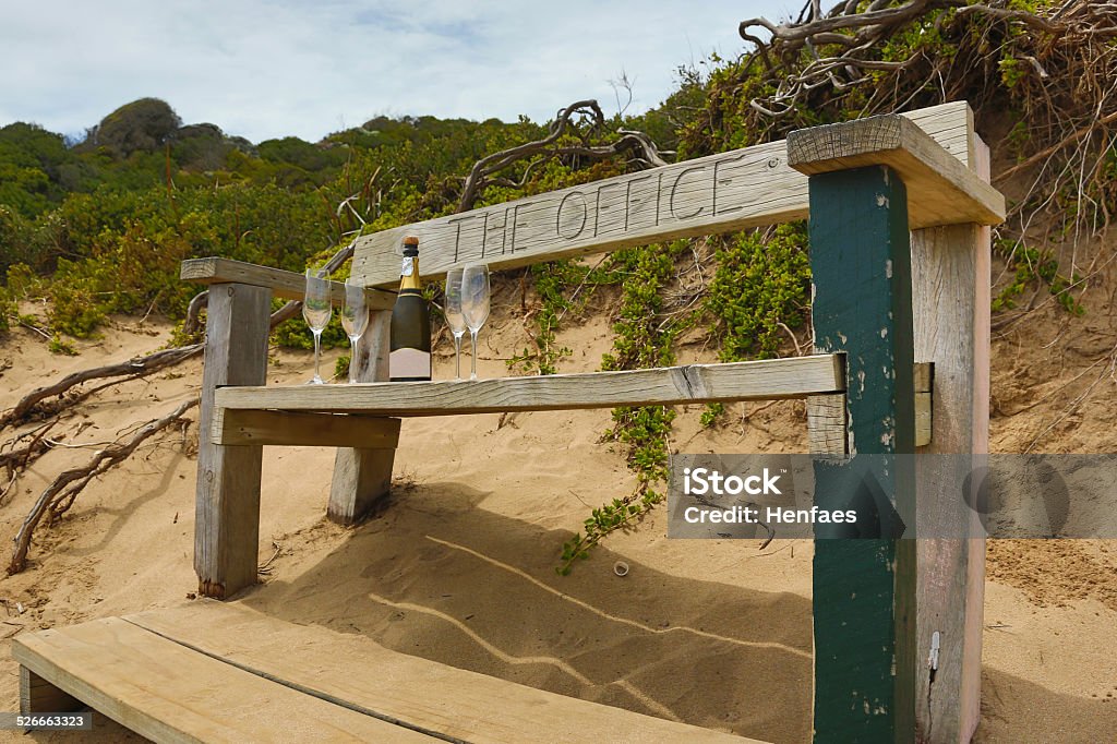 Bench named 'The Office' with wine glasses and champagne A beach side bench in Australia named The Office - with champagne and glasses on the seat ready to be filled Australia Stock Photo