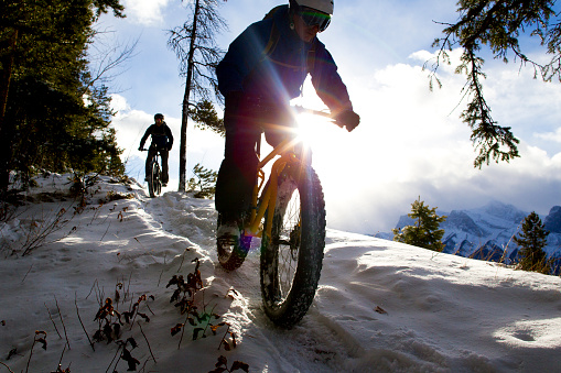 Two male cyclists enjoy a winter fat bike snow ride in Alberta, Canada.