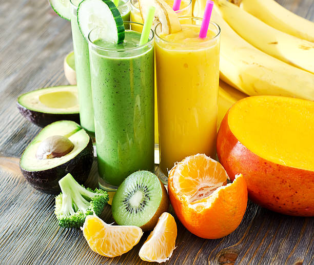 istock Green and yellow smoothie in glasses with ingredients on table 526664213