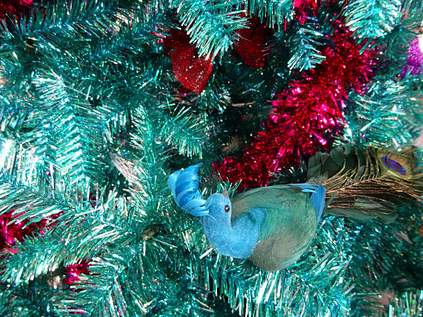 istock Tinsel Christmas tree, green / turquoise peacock decorations, glitter, red tinsel 526665025