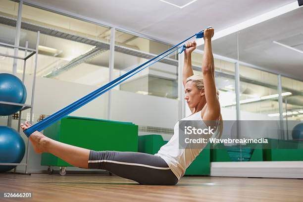 Side View Of Woman Using Resistance Band In Fitness Studio Stock Photo - Download Image Now