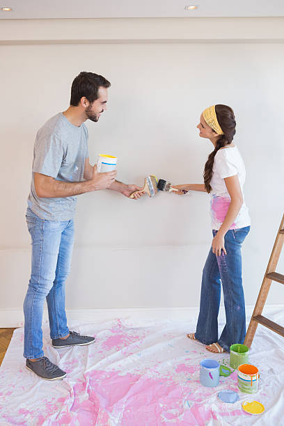 istock Cute couple painting the wall 526667007