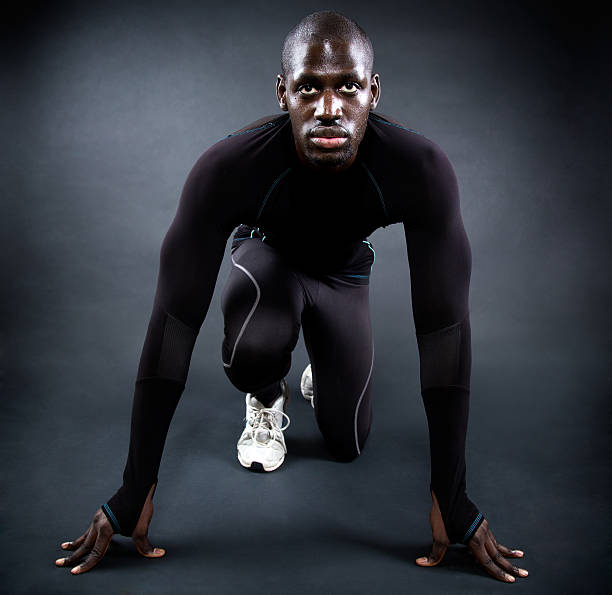 istock Athletic man running in black background. 526669597