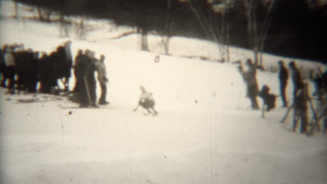 1939: Daredevil downhill skiers taking sharp turn with audience.