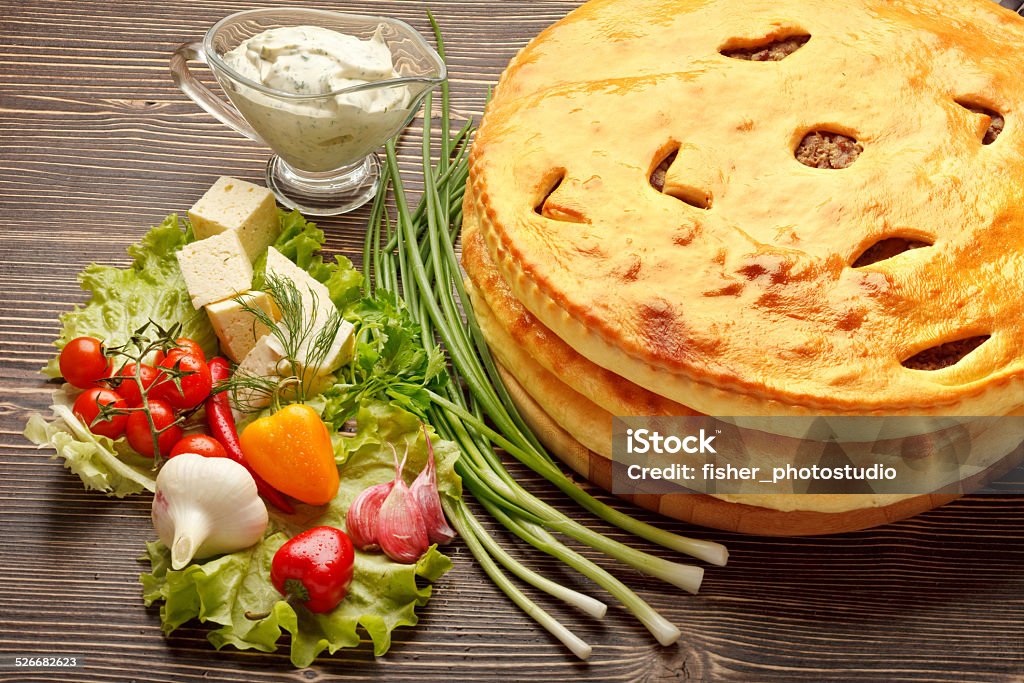Ossetian pies. A colorful photo of traditional delicious beef osetinian pie. Heap of traditional Ossetian pies on wooden background. Antipasto Stock Photo