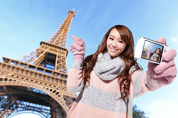 Happy travel woman take a selfie by camera with eiffel tower in Paris with blue sky