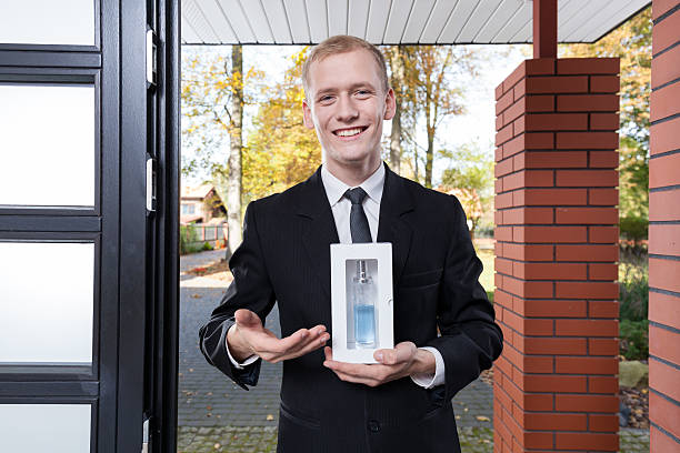 Smiling salesman selling perfume Smiling salesman standing at the door and selling perfume door to door salesperson photos stock pictures, royalty-free photos & images