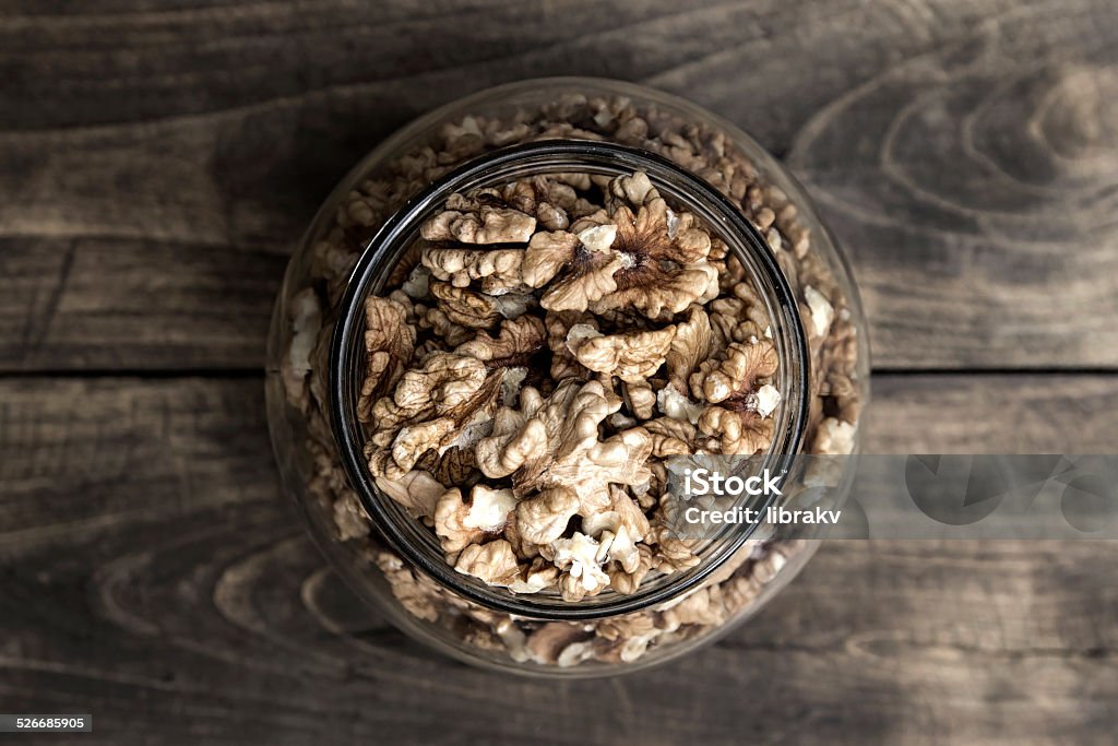 Glass jar with band full of cracked walnuts Glass jar with band full of cracked walnuts, from above Brown Stock Photo