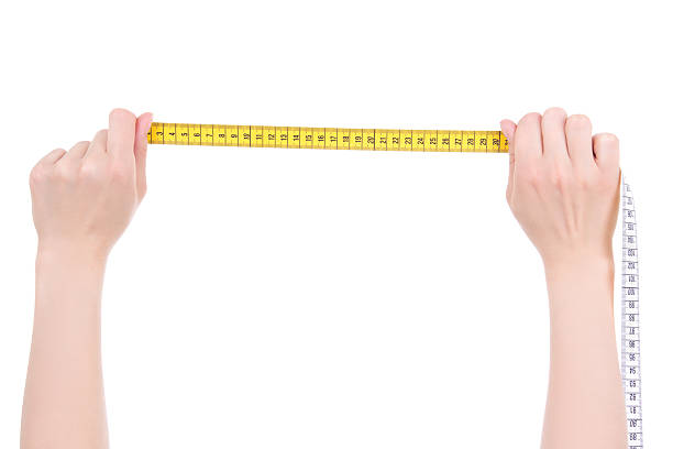 istock hands with yellow measure tape isolated on white background 526687815