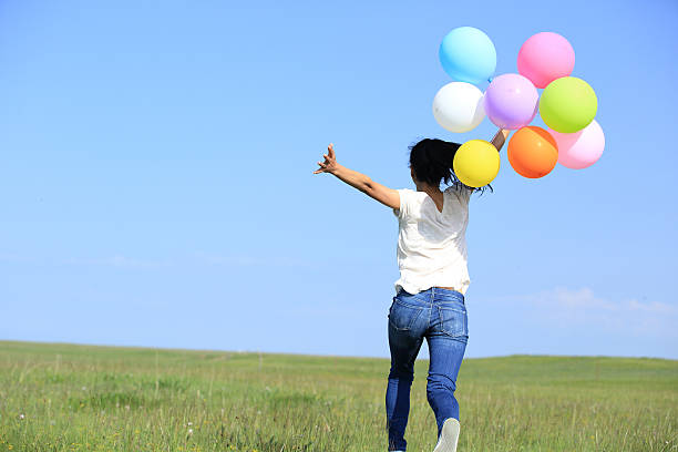 istock young asian woman  with colored balloons 526689419