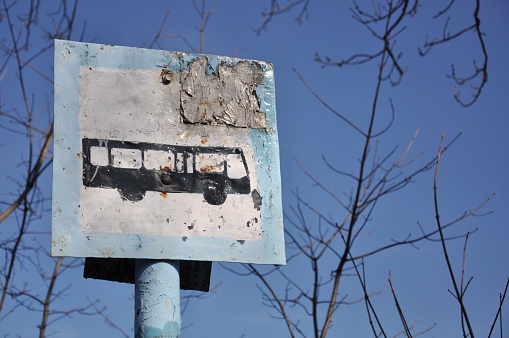 Rusty bus sign on pillar