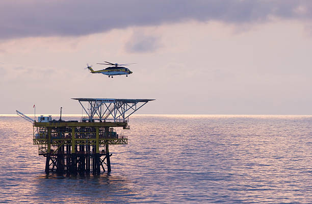 Helicopter and oil-rig An offshore helicopter transporting roughnecks to oil-rigs back country skiing photos stock pictures, royalty-free photos & images