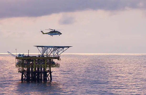 An offshore helicopter transporting roughnecks to oil-rigs
