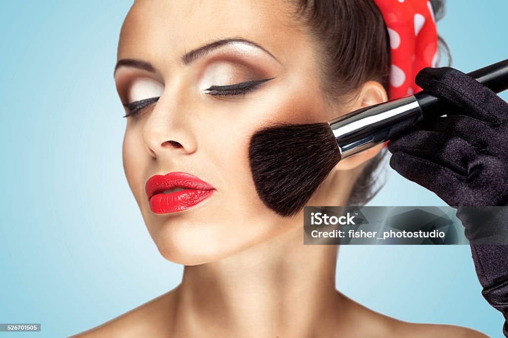 Silky smooth. Glamour girl with fashion makeup painting her cheek with brush. Adult Stock Photo