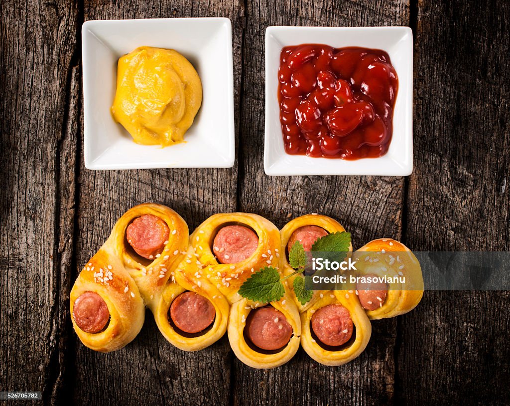 Mini hot dogs Mini hot dogs in pastry with kechup and mustard on wooden table Baked Pastry Item Stock Photo