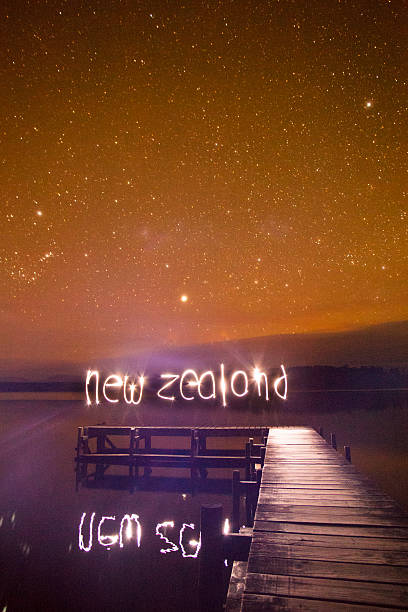 New Zealand sign over pier and starry night stock photo