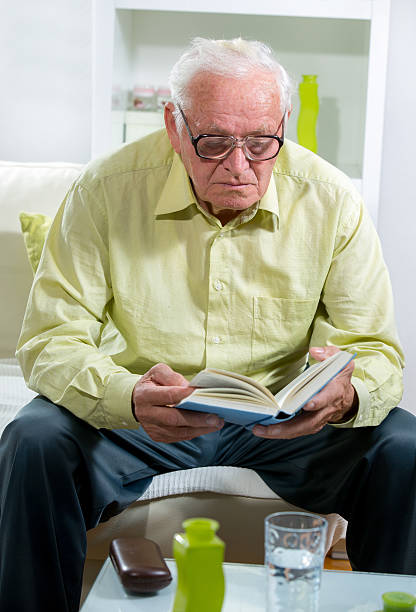 istock Senior Man Relaxing At Home Reading Book 526707963