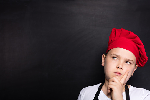 Child chef thinking on blackboard.