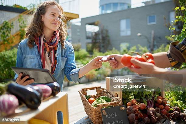 Friendly Woman Tending An Organic Vegetable Stall At A Farmer Stock Photo - Download Image Now